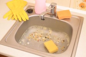 Dirty sink with sponge in it